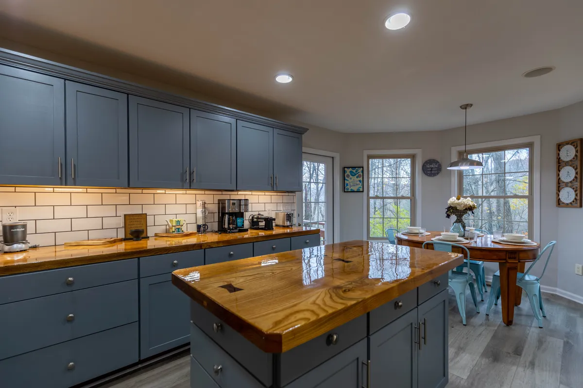 A view that seamlessly connects the kitchen island, dining table, and window views, blending the main living spaces. The layout suggests an easy flow for group gatherings, celebrations, and shared traditions.